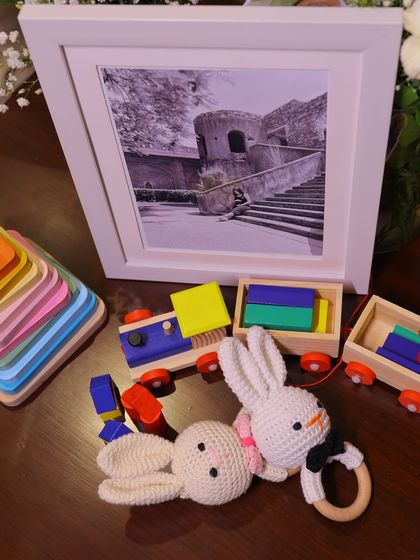 A close-up of the charming decor details, including a wooden toy train and handmade crochet bunny rattles. These elements add a touch of nostalgia and warmth to the celebration.
