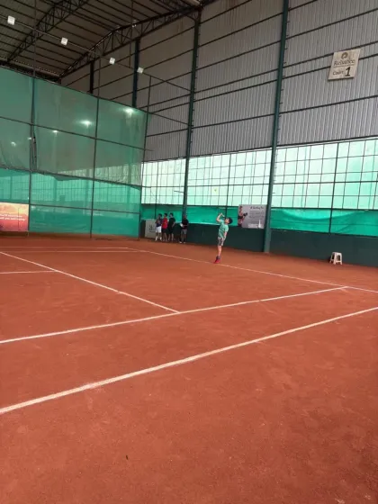 A player launching into a powerful serve during the inter-academy tournament.