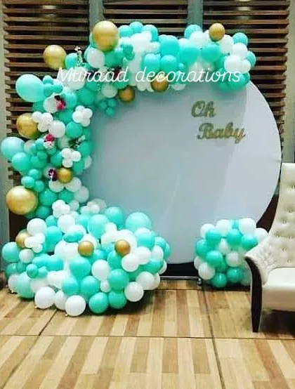 This 'Oh Baby' setup uses a refreshing color palette of teal, white, and gold. The design includes a circular backdrop, 'BABY' blocks, and a comfortable chair for the mom-to-be, making it a perfect photo corner.
