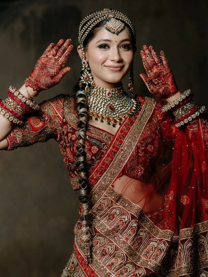 A playful and happy shot of the model, showing off her henna-adorned hands.