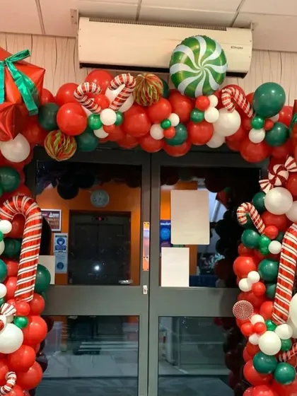 I create bold and festive entrances to welcome customers during the holidays. This Christmas balloon arch is packed with red, green, and white balloons, candy canes, and gift box accents.