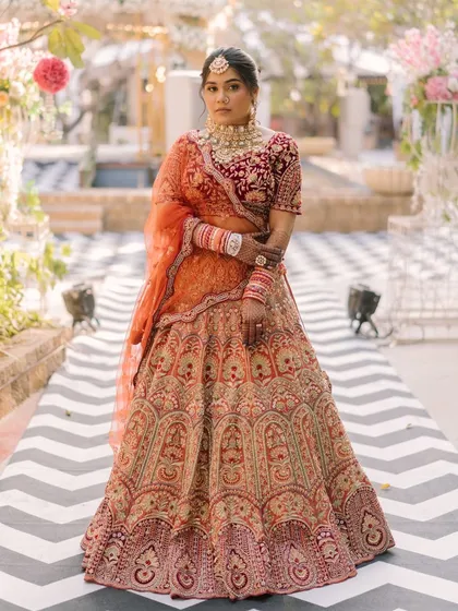 A powerful and confident pose from the bride. The makeup is bold and striking, matching the regal energy of her entire look.