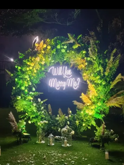 An outdoor proposal can be so magical. Here, I used a lush green circular arch mixed with pampas grass and a "Will You Marry Me?" sign to create a beautiful, natural backdrop for the big question.