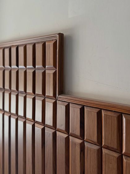 The beauty of custom woodwork is in the details. This beveled teak wood wall paneling adds incredible texture and a sense of classic craftsmanship to the space, transforming a simple wall into a feature.