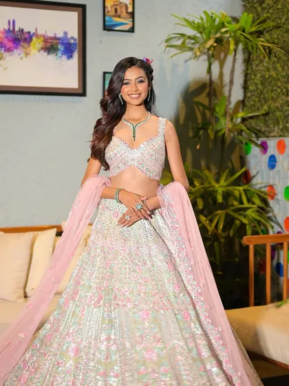 A joyful, full-length portrait of the bride. Her smile and the twirl of her lehenga show her happiness and confidence in her beautiful Mehendi look.