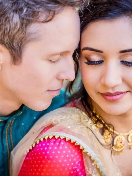 A serene close-up portrait of a couple with their eyes closed, resting their heads together. This image beautifully captures a moment of quiet intimacy and trust.
