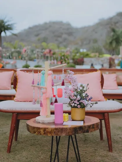 A coffee table detail from the 'Sunny Sway Soirée', featuring colorful candles and tassel art, adding to the boho-chic vibe.