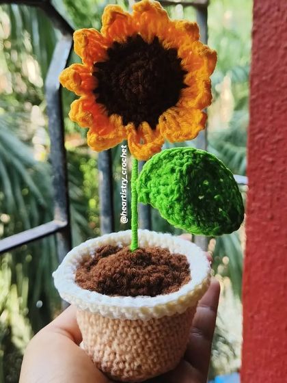 A clear, bright shot of the potted sunflower against a red background. The colors really pop, showing how vibrant this little creation is.