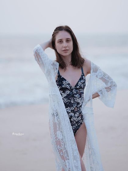 A relaxed beach portrait featuring a stylish lace cover-up. This is a great example of a lifestyle fashion shot that feels both elegant and effortless.