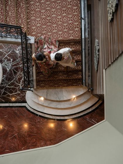 An artistic top-down shot of the couple on a marble staircase. We are always looking for unique angles and perspectives to tell your story.