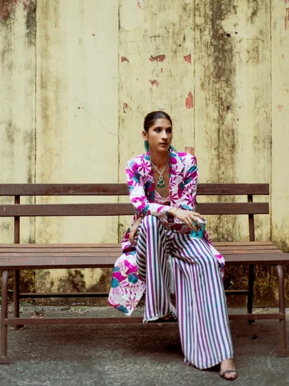 A quiet moment on a bench, but the outfit is still loud. This shows that even the most vibrant festive wear can have a relaxed and effortless feel.
