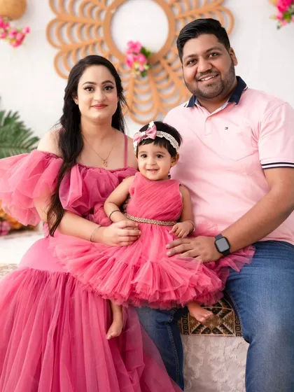 A complete family portrait in shades of pink. The coordinated outfits create a visually stunning and cohesive look, perfect for a celebratory photoshoot.