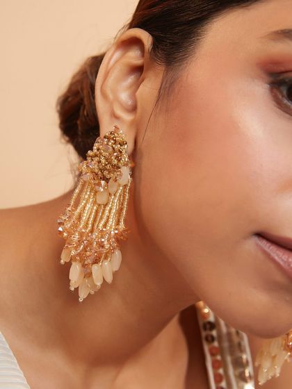 The warm, neutral tones of these beaded danglers make them incredibly versatile for any festive occasion.