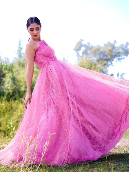 A dynamic shot of the model twirling in the pink gown, with the fabric flowing around her. This image captures a sense of freedom and joy, bringing the dress to life.