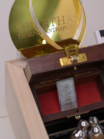 A detail shot of the 10-gram silver bar in its wooden case, a truly luxurious and valuable item included in the premium corporate gift box.