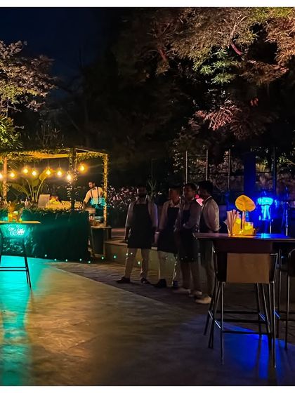 A long shot of the bar and dance floor area, showcasing the overall mood created by the strategic use of turquoise and warm yellow lighting.