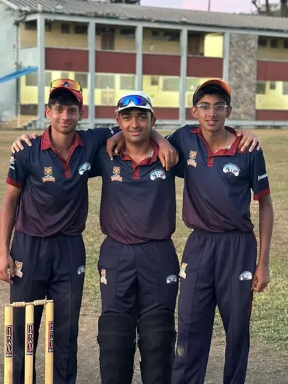 Three players posing together on the field in Trinidad.