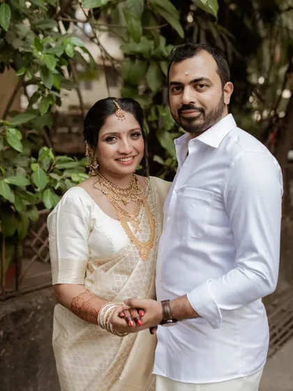 A beautiful formal portrait of the couple on their wedding day. Dressed in traditional South Indian attire, they hold hands, ready to begin their new journey together.