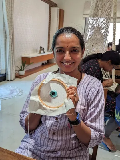 A participant proudly shows off the evil eye design she created, a popular and symbolic choice.