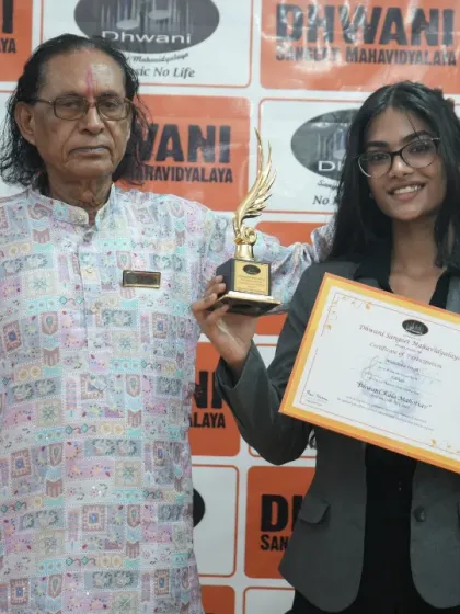 A senior guru with a promising young artist and her trophy.