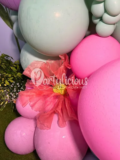 A close-up of a pastel balloon arrangement with a delicate paper flower, showing the beautiful textures we incorporate into our designs.
