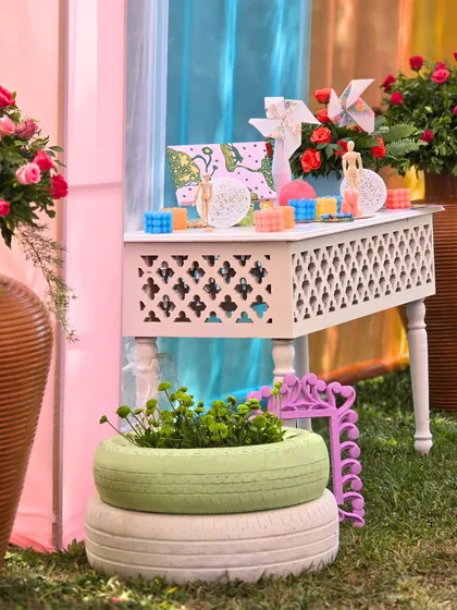 A console table decorated with art supplies, pinwheels, and other quirky objects, creating an interactive and thematic corner for guests to enjoy.