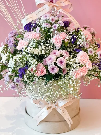 The beauty is in the details. A close-up of the fresh carnations and baby's breath, carefully arranged in a signature Hamper Lounge box, shows the quality of our floral designs.