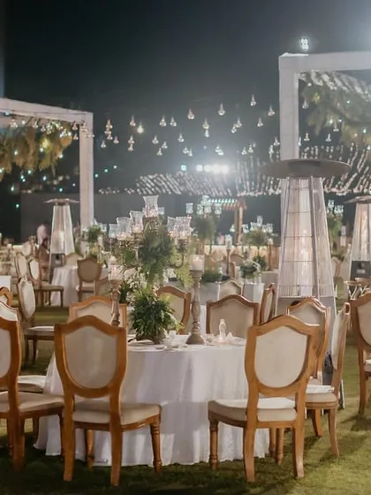 The magical ambiance of the 'Luxe Garden' dinner, with string lights, hanging glass bubbles, and candlelit tables.