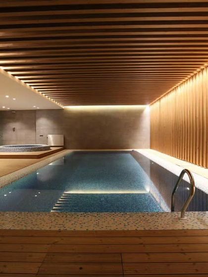 We also work on indoor luxury spaces. This project features an indoor swimming pool and jacuzzi area, beautifully finished with wooden decking and a slatted wood ceiling.