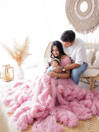 A full-length view showing the beautiful details of the mother's pink gown, creating a soft and romantic family portrait.
