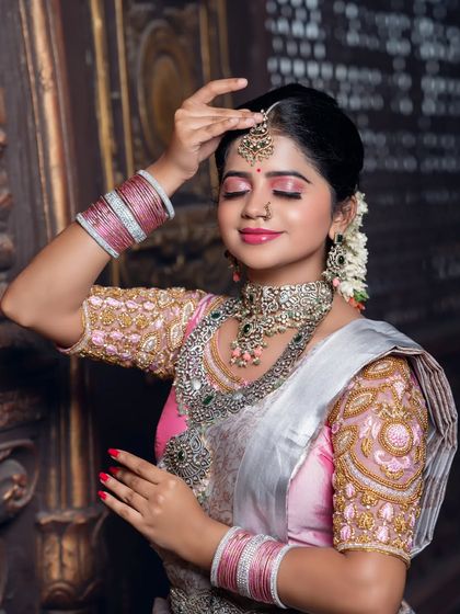 A serene close-up with eyes closed, focusing on the makeup and the beautiful maang tikka.