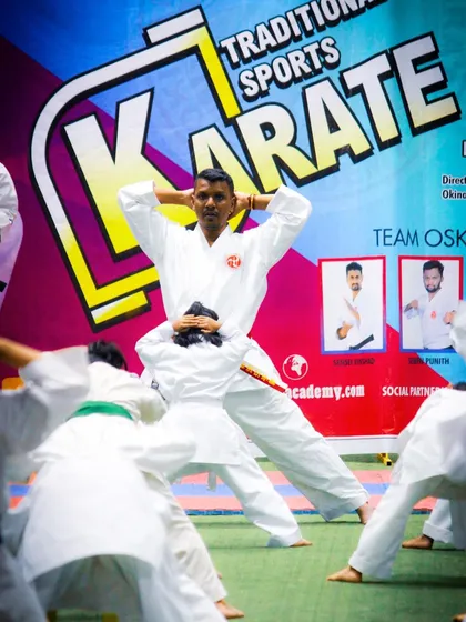 I guide students through a stretching routine during a grading event. Flexibility and physical conditioning are integral parts of our karate curriculum.
