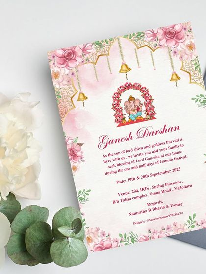 "Embrace the Blessings, Bloom in Joy!" A printed invitation for Ganesh Darshan that uses a beautiful floral arch and hanging temple bells to frame the deity, blending devotion with delicate design.