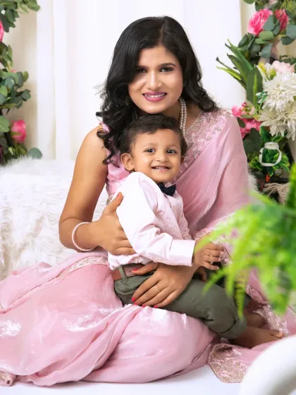 A candid, happy moment between a mother and her son, both sharing a huge smile for the camera.