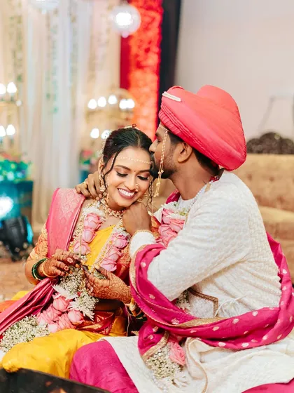 A sweet, intimate moment between the couple. The groom's kiss on her forehead is a testament to the love and joy of the day, with the bride's makeup looking flawless.