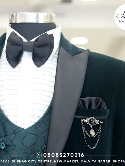 A close-up of the green velvet tuxedo, showing the geometric pattern on the waistcoat and the fine details of the lapel pin. Every element is chosen to create a cohesive and luxurious feel.