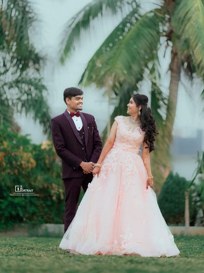 A sweet glance between the happy couple. This blush pink ball gown with floral appliqué is a dreamy choice for an outdoor engagement or pre-wedding shoot.