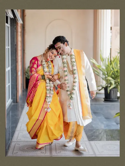 A sweet and tender moment as the newly married Maharashtrian couple walks together, the bride resting her head on her groom's shoulder.