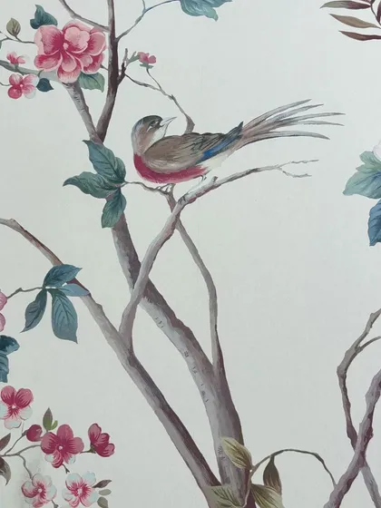 This close-up highlights the delicate details of a bird nestled among pink blossoms. Our hand-painted wallcoverings are designed to bring a story of timeless elegance and natural beauty to your interiors.