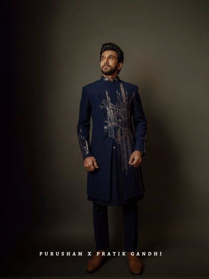 With my tailored precision, Pratik Gandhi proves that style is the ultimate power move. He wears a custom navy blue bandhgala with striking, architectural embroidery.