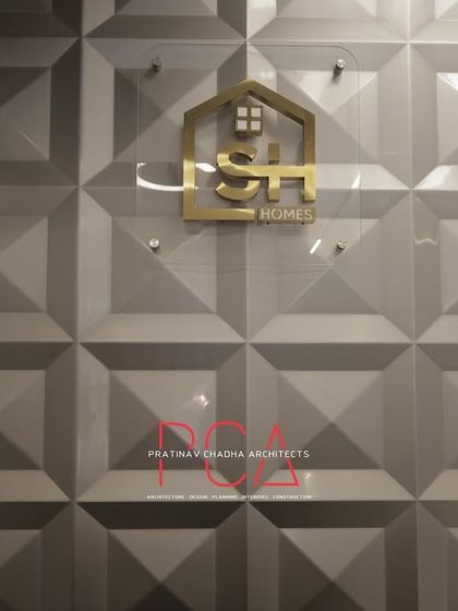 A close-up of the StyleIn Homes logo mounted on a 3D geometric wall panel, an example of integrated branding.