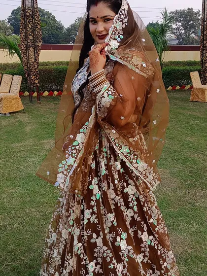 A playful shot of the client peeking from behind her sheer brown dupatta.