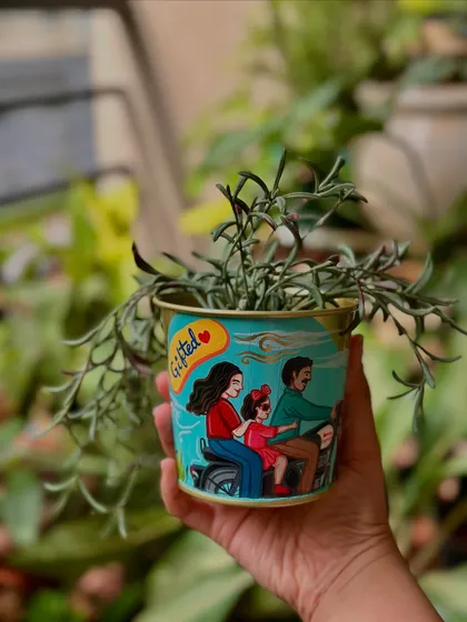 A unique Father's Day gift: a hand-painted planter showing a family of three on a scooter.