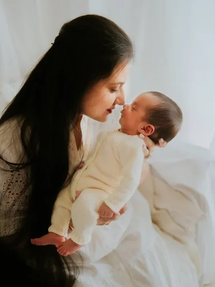 A mother and her newborn, nose to nose. This intimate moment is a beautiful representation of their new bond.