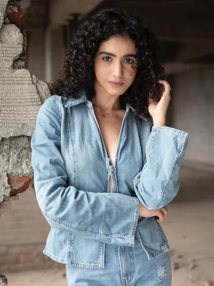 Another shot from the denim series, highlighting the model's natural curly hair. The makeup remains understated, proving that less is more for this kind of photoshoot.