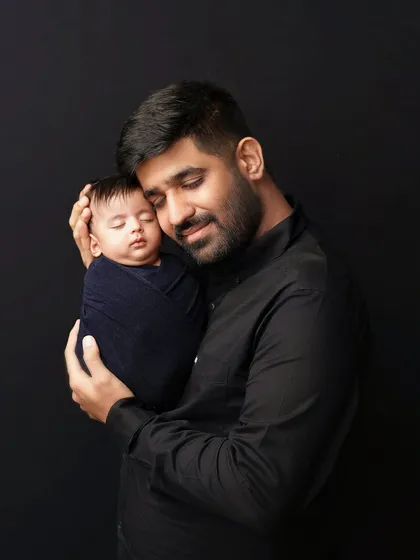 A father cradles his sleeping newborn, a look of pure adoration on his face. These quiet moments between a dad and his baby are incredibly special to capture.