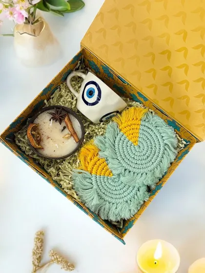 Here is my Nurture and Protection hamper, which blends sustainable choices with traditional sentiments. It features an eco-friendly coconut shell candle, handmade macrame coasters, and a ceramic evil eye mug to bring good vibes into your home.