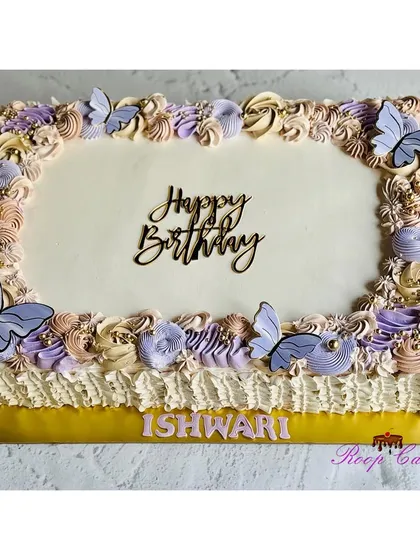 A lovely sheet cake decorated with pastel purple and beige rosettes and delicate butterflies.