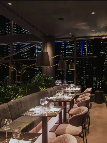 The interior of One40 Rooftop, where plush seating and custom lighting create an intimate atmosphere against the vast city view. This space was featured in Forbes for its elevated design.