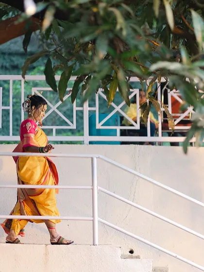 A candid shot of the bride walking, showcasing the beautiful drape of her Nauvari saree.